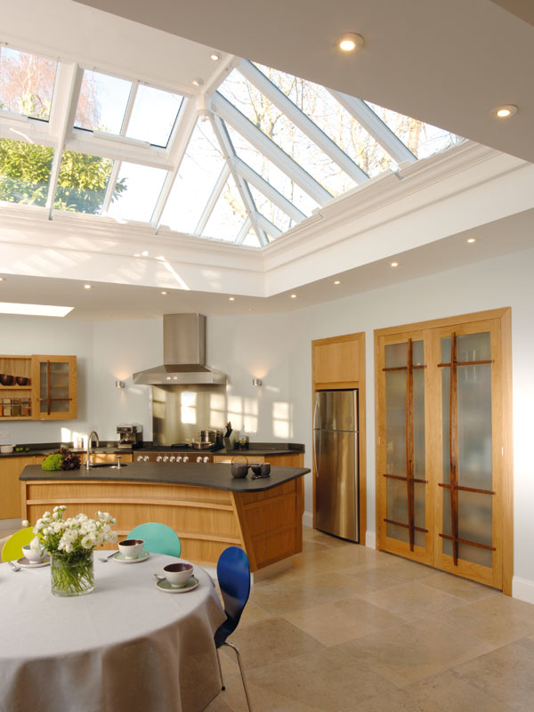 An orangery roof as seen from inside flooding natural light into a kitchen area