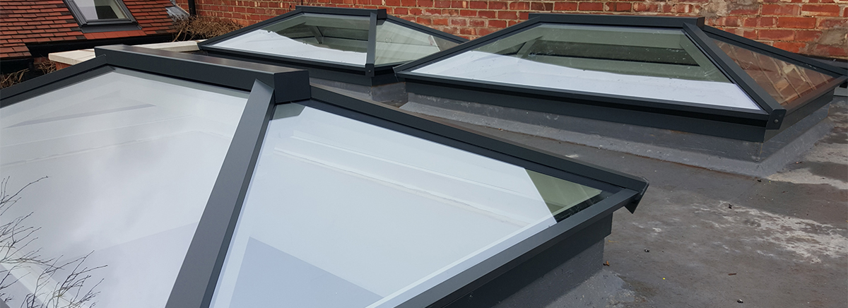The Worcester and Lincoln Urban-style aluminium roof lanterns with slim black frames, offering a sleek and contemporary aesthetic while maximizing natural light in a flat roof setting.