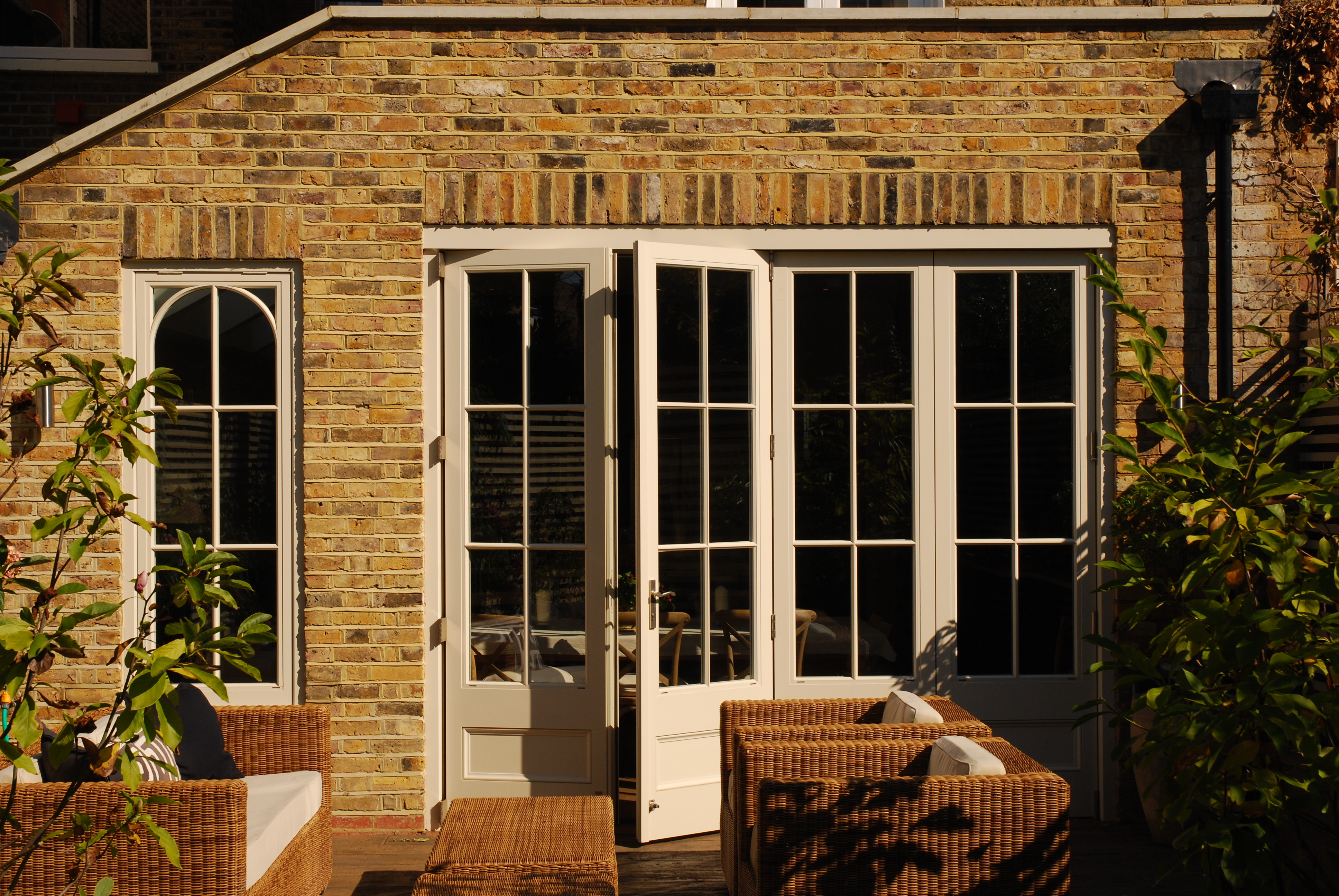 Classic bi-fold doors with a panel base and elegant glazing pattern, seamlessly blending indoor and outdoor living.