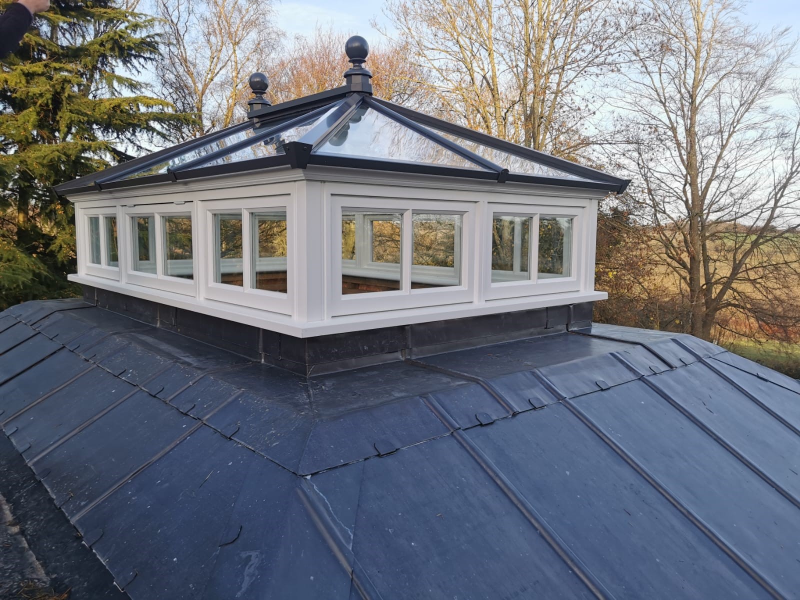A beautifully crafted timber roof lantern with side frames, featuring opening vents to enhance airflow and natural light in a traditional setting.