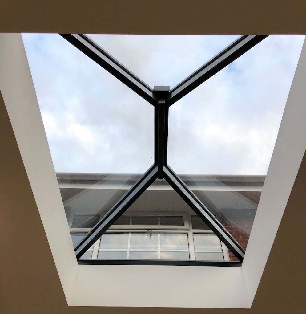 Interior view of The Chester aluminium roof lantern, showcasing its sleek black-framed design with expansive glazing that maximizes natural light in a modern extension.